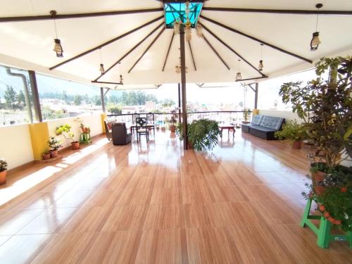 a large room with a wooden floor and a large umbrella at Hotel Quilla House 2 in Urubamba