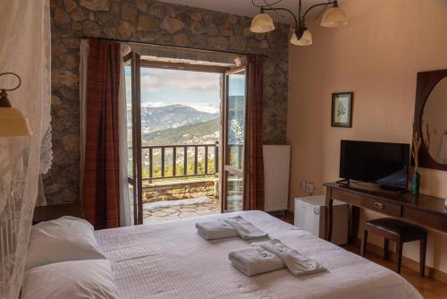 a bedroom with a bed and a view of a balcony at Karyatis Resort in Synikia Mesi Trikalon