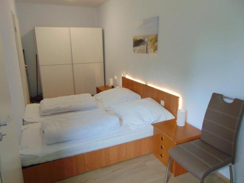 1 dormitorio con 1 cama con silla y escritorio en Ridders Ferienpark 1 319, en Hahnenklee-Bockswiese