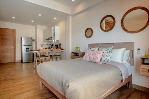 a bedroom with a large bed and a kitchen at Condos with ocean view pool in Av 10 & 60 street in Playa del Carmen