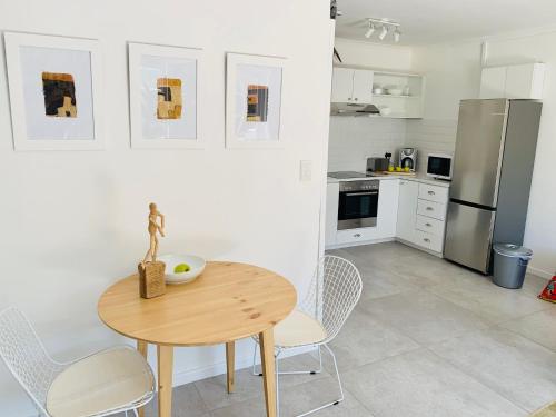 a kitchen with a table and chairs and a refrigerator at BEAUTIFUL VIEW Garden Apartment in Cape Town