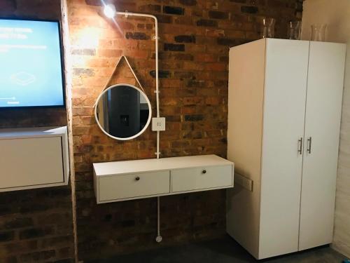a bathroom with a white dresser and a mirror at Maboneng Craftsmanship place in Johannesburg