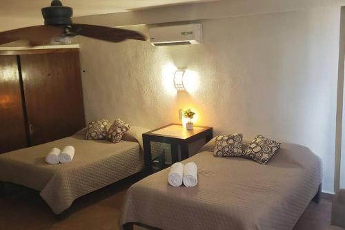 a room with two beds and a table with a lamp at Departamento GRANDE con 2 recamaras con aire 5 camas wifi 115mb, cocina .Cochera techada, #4 in Ciudad Valles