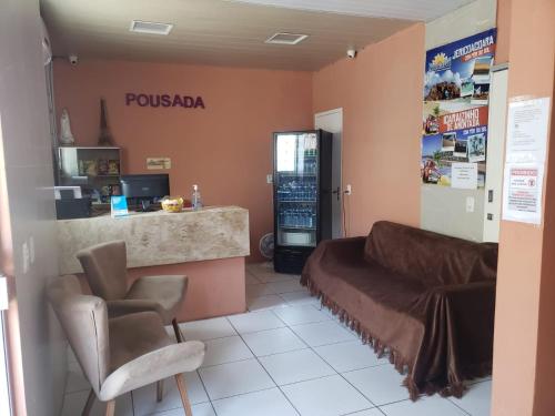 a salon with a couch and two chairs in a room at Pousada Dom Kilmer in Fortaleza