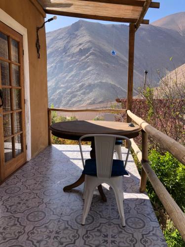 a table and chairs on a patio with a mountain in the background at Cabañas Elquimista in Pisco Elqui