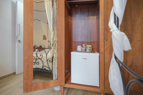 a small refrigerator in a room with a mirror at Casaldo's rooms in Florence
