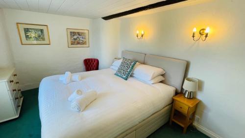 - une chambre avec un lit blanc et 2 serviettes dans l'établissement Donore - Quintessential English Cottage close to Dittisham Quay, à Dittisham
