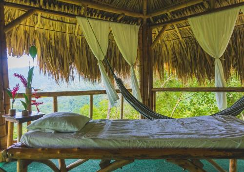 a hammock in a room with a view of the ocean at Minca Ecohabs Hotel in Minca