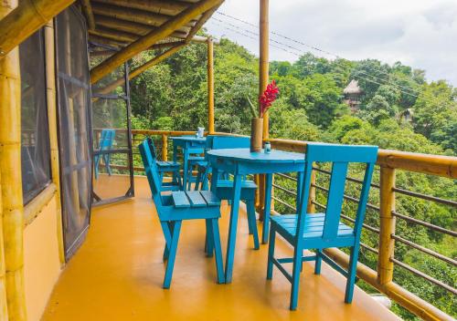 a blue table and chairs on a balcony at Minca Ecohabs Hotel in Minca