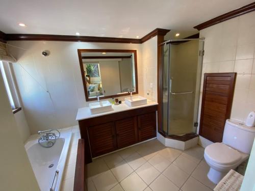a bathroom with a sink and a shower and a toilet at Grand Baie Beach Penthouse in Grand-Baie