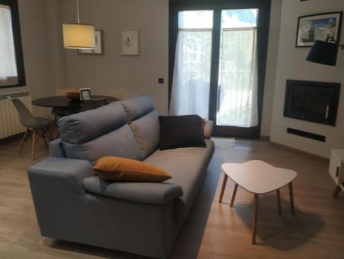 uma sala de estar com um sofá e uma mesa em CHECK-IN CASAS La Tuca em Benasque