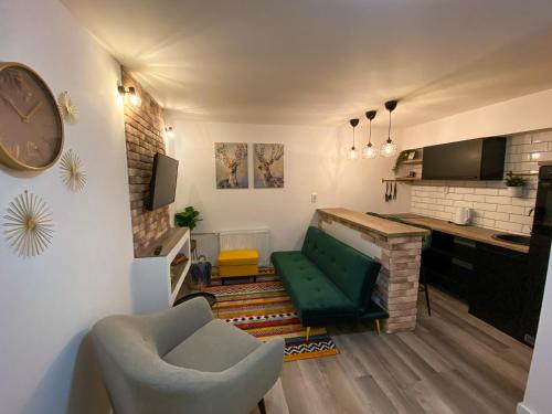 a living room with a green couch and a desk at Apartment Sleep & Fly Zagreb Airport in Velika Gorica