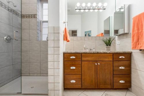a bathroom with a wooden vanity and a shower at The Wrigleyville VIP-200 Steps from Wrigley Field in Chicago
