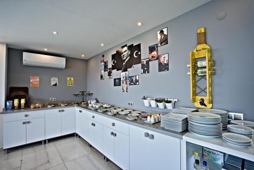 a kitchen with white cabinets and plates on the wall at Stonehillkaş in Kas