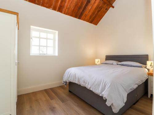 Un dormitorio con una cama grande y una ventana en Swallow Cottage, en Sandbach