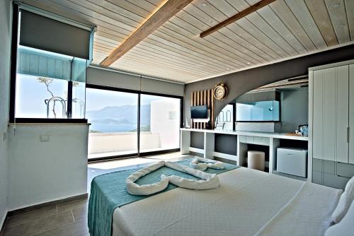 a bedroom with a large bed and large windows at Stonehillkaş in Kas