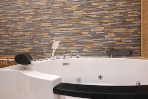 a white bath tub in a room with a brick wall at Casaldo's rooms in Florence