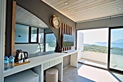 a room with a clock on the wall and windows at Stonehillkaş in Kas