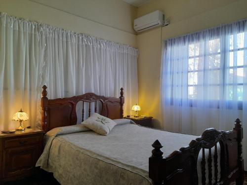 1 dormitorio con 1 cama y una ventana con cortinas en Casa una habitación, en Colonia del Sacramento