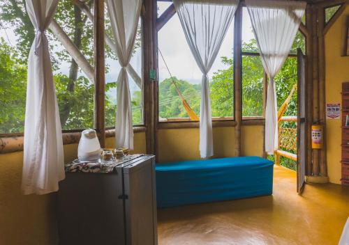 a room with a window with a bench and a table at Minca Ecohabs Hotel in Minca