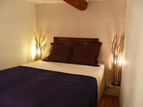 1 dormitorio con 1 cama con almohadas marrones en Bed and Breakfast Jardin de Marie, en Aix-en-Provence