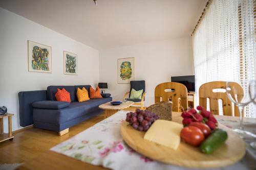 a living room with a table with a bowl of fruit on it at Landhaus Weiß in Bad Reichenhall