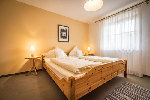 um quarto com uma cama de madeira e uma janela em Landhaus Weiß em Bad Reichenhall