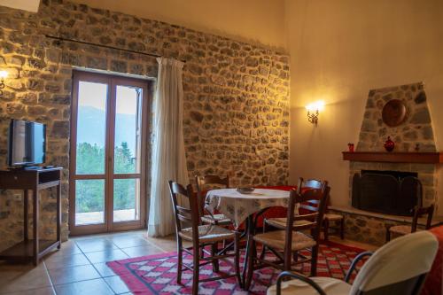 a dining room with a table and a fireplace and a television at Karyatis Resort in Synikia Mesi Trikalon
