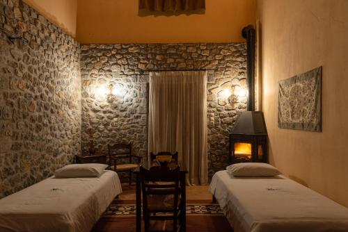 a hotel room with two beds and a fireplace at Karyatis Resort in Synikia Mesi Trikalon