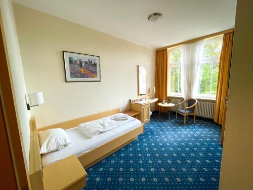 Habitación de hotel con cama y escritorio en Bischofshof Braustuben en Regensburg