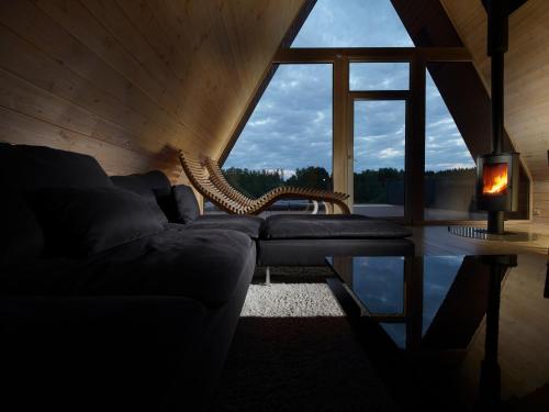 a living room with a couch and a large window at 3kampai in Molėtai