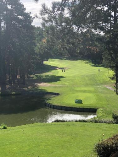 a view of a golf course with a pond at Chambre d'Hôte Touquet's Garden in Cucq