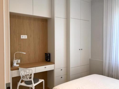 a bedroom with a desk and a chair next to a bed at Apartament Szpitalna in Poznań