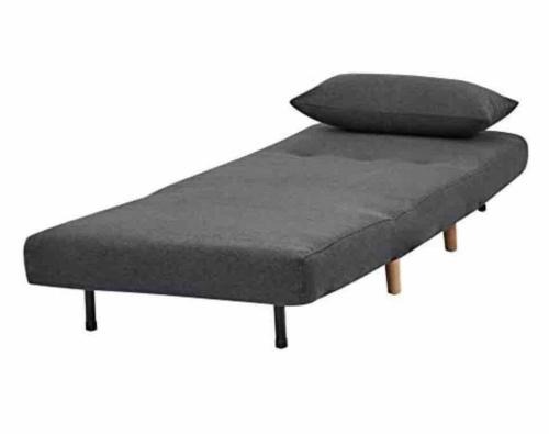 a bed frame with a gray mattress and pillows at The Bison Cabin - The Cabins at Rim Rock in Austin