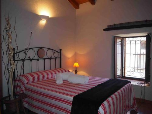 una camera con un letto con una coperta a righe rosse e bianche di Casa Rural El Guindo ad Ávila