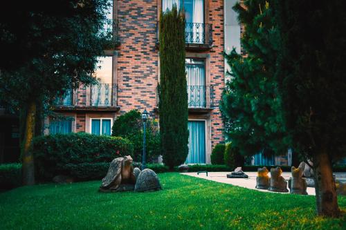 a building with a group of statues in the grass at Quinta del Rey Hotel in Toluca