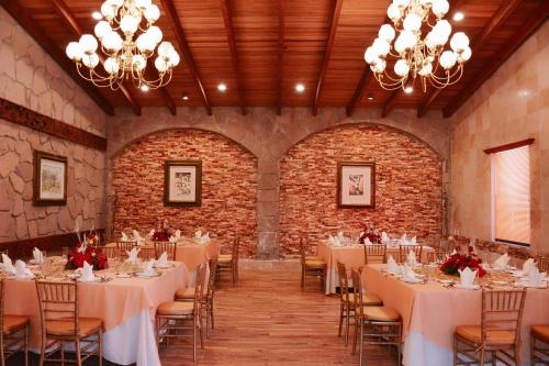 a banquet hall with tables and chairs and chandeliers at Quinta del Rey Hotel in Toluca