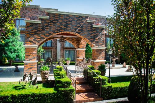 a brick house with an archway in a garden at Quinta del Rey Hotel in Toluca