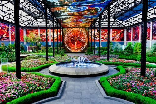 a fountain in the middle of a garden with flowers at Quinta del Rey Hotel in Toluca