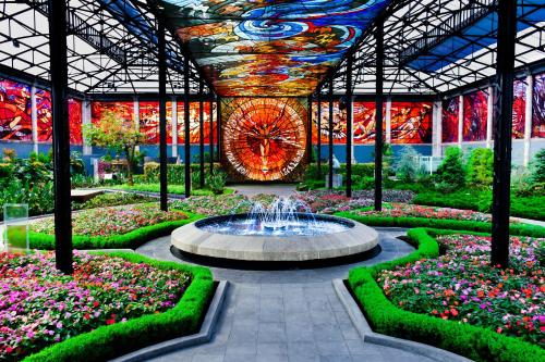 una fuente en medio de un jardín con flores en Quinta del Rey Hotel en Toluca
