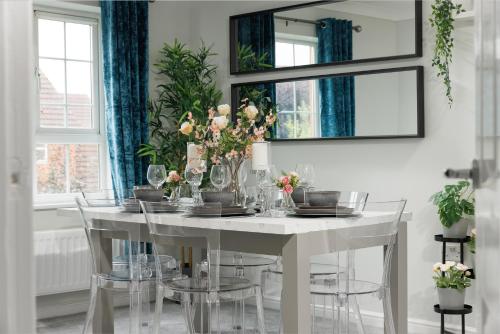 a white dining room table with chairs and a mirror at Home From Home Northampton in Northampton