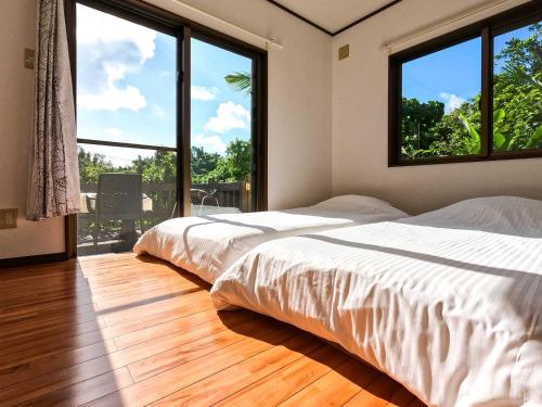 two beds in a room with two large windows at Kāchibai - Vacation STAY 21657v in Tōzato