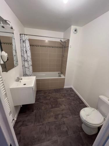 La salle de bains est pourvue de toilettes, d'un lavabo et d'une baignoire. dans l'établissement Appartement rez de chaussée avec parking privé, à Orléans