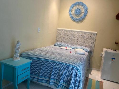 a small bedroom with a bed and a blue nightstand at Pousada Paracuru Surf in Paracuru