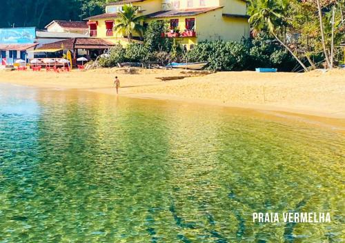 a person standing on the shore of a beach at Pousada Lagamar in Praia Vermelha