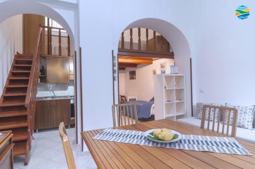 uma cozinha e uma sala de jantar com uma mesa com um prato de comida em Casamare em Amalfi