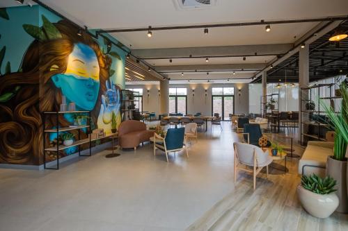 a large lobby with chairs and a mural at Slaviero Ponta Grossa in Ponta Grossa