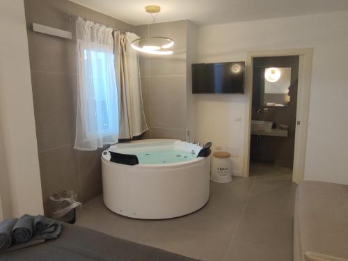 a bathroom with a tub in the middle of a room at Live Home Rooms in Villasimius