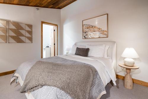 a white bedroom with a bed and a lamp at Skycrest Penthouse 1733 in Big Sky