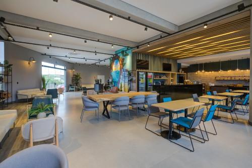 a restaurant with tables and chairs in a room at Slaviero Ponta Grossa in Ponta Grossa